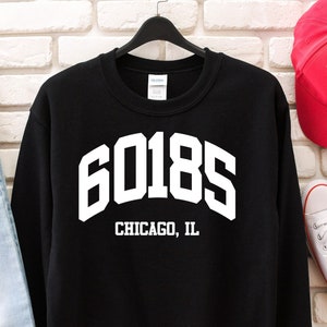 Puede incluir: Sudadera negra con texto blanco que dice "60185 CHICAGO, IL".