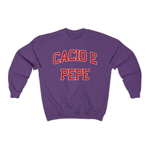 Puede incluir: Sudadera morada con el texto "Cacio e Pepe" en rojo.