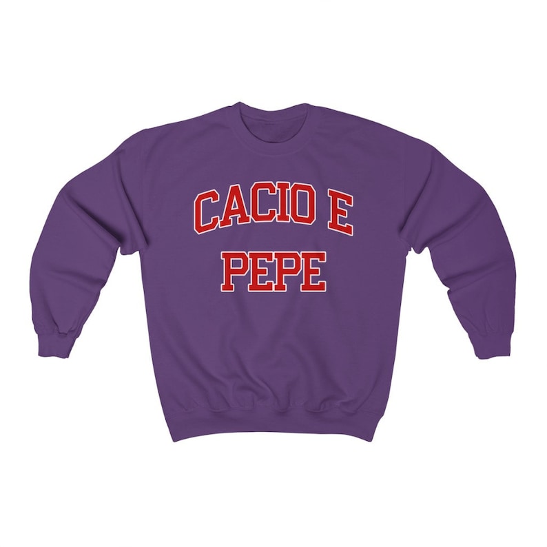 Puede incluir: Sudadera morada con el texto "Cacio e Pepe" en rojo.