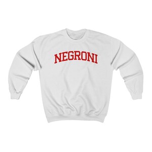 May include: White sweatshirt with red text that reads "NEGRONI" in a collegiate font.