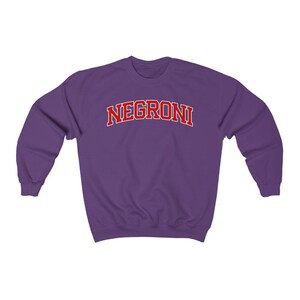 May include: Purple sweatshirt with the word "NEGRONI" in red letters.
