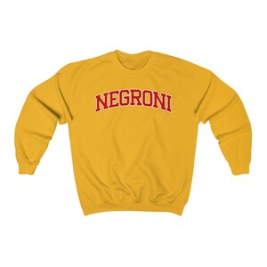 May include: A yellow sweatshirt with the word "NEGRONI" printed in red on the front.