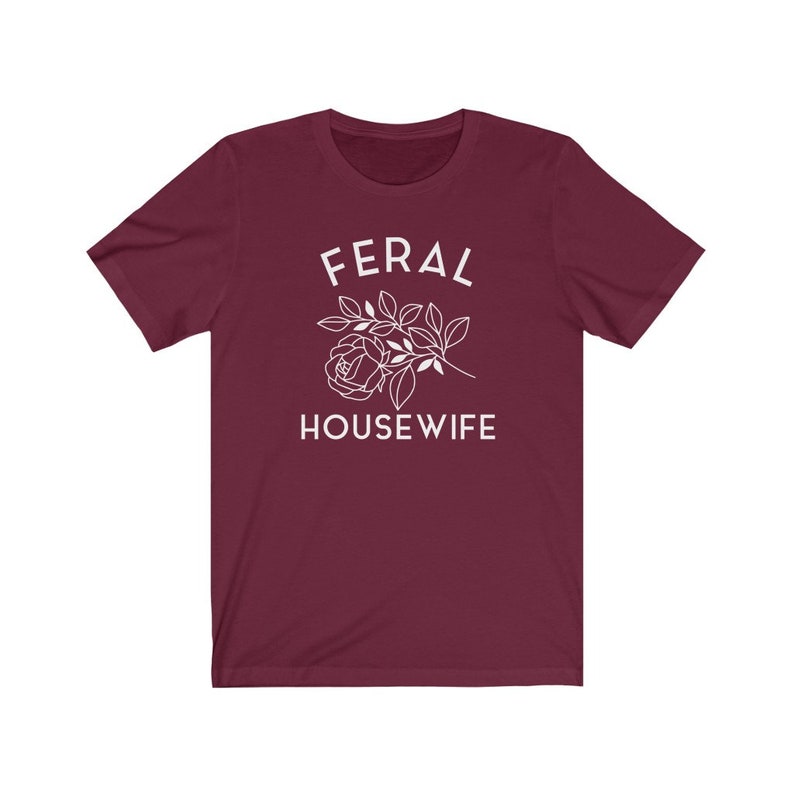 May include: Burgundy t-shirt with white text that reads "Feral Housewife" and a stylized white rose with leaves.