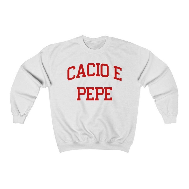 Puede incluir: Sudadera blanca con texto rojo que dice "Cacio e Pepe" en una fuente universitaria.