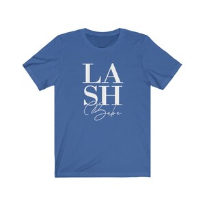 Pu&ograve; includere: T-shirt blu reale con la scritta bianca "LASH Babe". La parola "LASH" &egrave; impilata, con "SH" in un corpo pi&ugrave; grande. "Babe" &egrave; scritto in corsivo. Un capo casual per tutti i giorni.