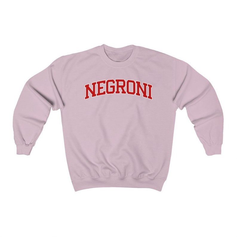 May include: A light pink sweatshirt with the word "NEGRONI" printed in red on the front.
