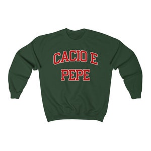 Puede incluir: Una sudadera verde oscuro con el texto "Cacio e Pepe" en letras rojas.