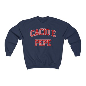 Puede incluir: Sudadera azul marino con letras rojas que dicen "Cacio e Pepe".