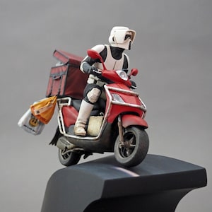 May include: A white-armoured figure riding a red scooter with a delivery box and bags. The figure is wearing a white helmet with a black visor.