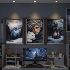 Könnte beinhalten: Drei gerahmte Kunstdrucke mit Wintermotiven hängen über einem Schreibtisch. Die Drucke zeigen eine verschneite Landschaft, einen Mann mit einem weißen Wolf und eine Laterne in einer Schneeszene. Ein Computermonitor zeigt ein Fantasy-Bild.