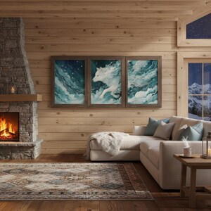 Könnte beinhalten: Drei gerahmte Kunstdrucke, die einen weißen Wolf zeigen, der durch eine wirbelnde blau-weiße abstrakte Landschaft rennt. Das Kunstwerk wird über einem cremefarbenen Ecksofa in einem gemütlichen Wohnzimmer mit Kamin und Teppich ausgestellt.