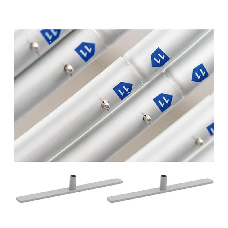 May include: Two silver metal stands with a round base and a flat top. The stands are designed to hold a banner or sign.