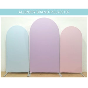 May include: Three arched fabric backdrops in light blue, lavender, and pink. The backdrops are made of polyester and stand on metal bases.