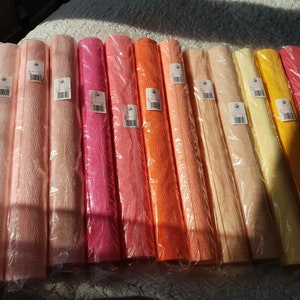 May include: Assortment of 10 rolls of crinkled tissue paper in various shades of pink, orange, and yellow. Each roll is 50 cm x 50 cm.