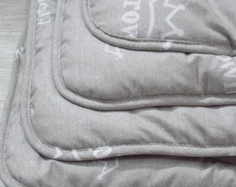 May include: A stack of three grey and white patterned throw pillows with white stitching around the edges.
