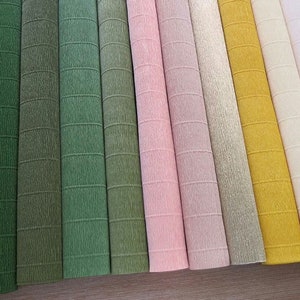 May include: Assortment of 12 rolls of crepe paper in various shades of green, pink, gold, and white. The paper has a textured, crinkled appearance.