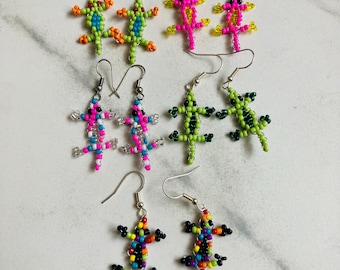 May include: Five pairs of lizard-shaped dangle earrings crafted from colourful seed beads. The collection includes green and orange, bright pink and yellow, pink and blue, lime green and black, and multi-coloured beaded lizard designs.