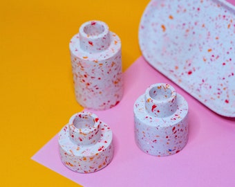 Terrazzo Candle Holders in light grey, with red pink and orange flecks made out of eco-friendly jesmonite