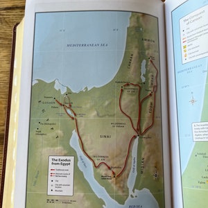 May include: Open book page with a detailed map illustrating "The Exodus from Egypt." The map features a red route tracing the journey, with labels for locations like Goshen, Sinai, and the Red Sea. The map is surrounded by text and geographical details.