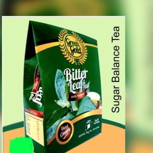 Peut inclure: Un paquet de thé vert et or Green Gold Bitter Leaf Tea. Le paquet porte l'inscription "Sugar Balance Tea" sur le côté droit et "Bitter Leaf Tea 100% Natural" sur le devant. Le paquet porte également un logo vert et or avec le texte "Green Gold".
