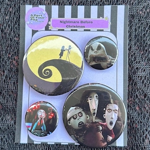 May include: A set of four circular pin-back buttons featuring Nightmare Before Christmas imagery, including Jack and Sally on a hill, a close-up of Jack, a character portrait, and a trio of characters, all mounted on a striped display card.