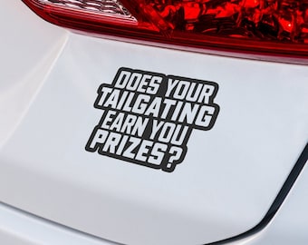 以下が含まれることがあります： 「Does your tailgating earn you prizes?」と書かれた黒いバンパーステッカーが貼られた白い車