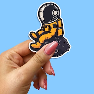 Astronaut Sitting on Meteor Sticker - Cute Cartoon Outer Space Decal for Laptops, Water Bottles, and Scrapbooks, Adorable Space Travel Decal