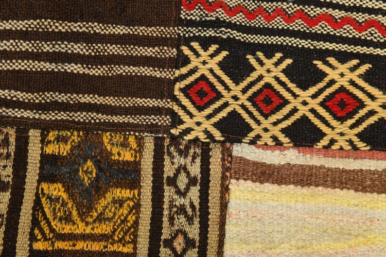 May include: A textile patchwork featuring various woven patterns. One section displays brown and white stripes, another shows a black background with yellow diamond shapes and red centers, and a third includes yellow and brown geometric motifs.