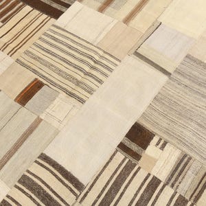 May include: A patchwork rug with a variety of rectangular and square patches. The rug features a neutral color palette with shades of beige, cream, and brown. Some patches have striped patterns.