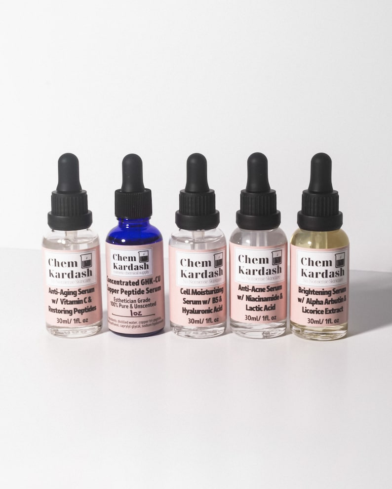May include: Five small glass bottles with blue and gold caps, each containing a serum. The bottles are labeled "Chem Kardash" and list different serum types, including anti-aging, concentrated peptide, cell moisturizing, anti-acne, and brightening.