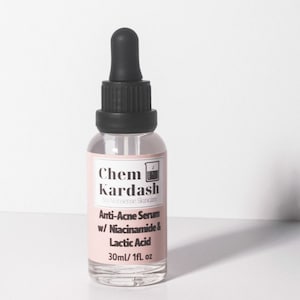 May include: A clear glass bottle with a black dropper top and a white label. The label reads "Chem Kardash No Nonsense Skincare Anti-Acne Serum w/ Niacinamide & Lactic Acid 30ml/1fl. oz"