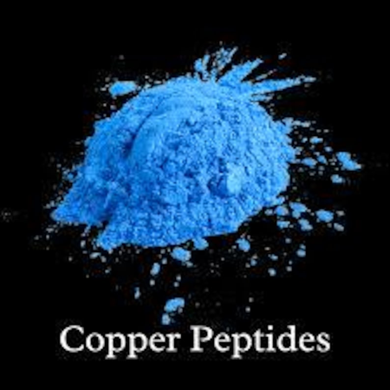 Puede incluir: Primer plano de un mont&oacute;n de polvo azul brillante con part&iacute;culas dispersas sobre un fondo negro. El texto "Copper Peptides" se muestra en blanco en la parte inferior de la imagen.