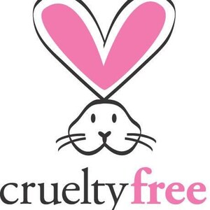 May include: A black and white illustration of a bunny head with pink heart-shaped ears. The words "cruelty free" are written below the bunny in black and pink text.