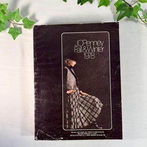 May include: A dark brown JCPenney Fall & Winter 1978 catalog with a rectangular white-bordered inset featuring a person wearing a green and purple plaid vest and matching pleated skirt. The cover includes white text and small print at the bottom.