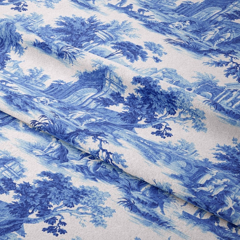 Puede incluir: Tela de toile azul y blanca con un patr&oacute;n repetido de &aacute;rboles, edificios y figuras. La tela tiene una superficie texturizada y un aspecto ligeramente descolorido.