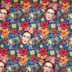 Op de afbeelding: Een kleurrijke stof met een herhalend patroon van Frida Kahlo's gezicht omringd door bloemen. De bloemen zijn in tinten rood, geel, oranje, roze, blauw en groen.