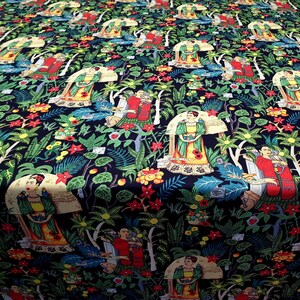 May include: A black fabric with a repeating pattern of a woman in a green dress and a red dress, surrounded by tropical plants and flowers. The woman is holding a bird in her hand. The fabric is perfect for crafting projects, quilting, and home decor.