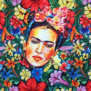 Op de afbeelding: Een kleurrijk bloemenpatroon met een schilderij van Frida Kahlo in het midden. Het schilderij is een close-up van haar gezicht met een bloemenkrans op haar hoofd.