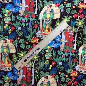May include: Black fabric with a colorful repeating pattern of Frida Kahlo, parrots, flowers, and other tropical elements. The fabric is measured with a ruler in inches.