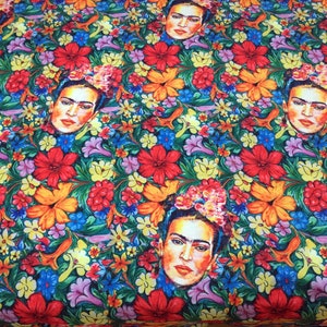 Op de afbeelding: Een kleurrijke stof met een herhalend patroon van Frida Kahlo's gezicht omringd door bloemen. De bloemen zijn in tinten rood, geel, oranje, roze, blauw en groen.