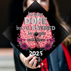 May include: A black graduation cap with a pink brain design and the text "It's been DOPE but I'm PSYCHED to get outta here 2025".