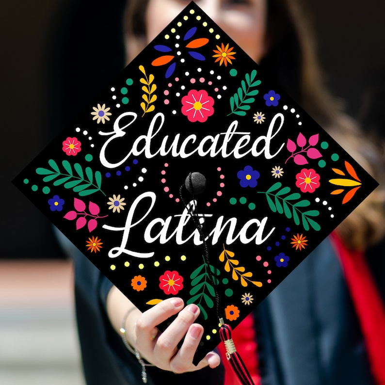 May include: Black graduation cap with colorful floral designs and the text "Educated Latina" in white.