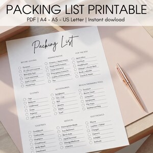 Peut inclure: Une liste de colisage imprimable avec le titre "Packing List" en écriture élégante. La liste est organisée en catégories telles que "Avant de partir", "Vêtements" et "Accessoires". Un stylo or rose repose sur la surface rose.