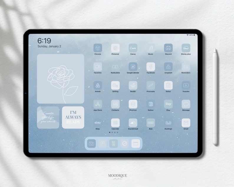 Puede incluir: Una pantalla de iPad azul y blanca con un fondo azul e iconos blancos. Los iconos son para aplicaciones como Chrome, Pinterest, C&aacute;mara, M&uacute;sica, Discord, Disney Plus, FaceTime, Redbubble, Google Calendar, Facebook, Unsplash, Recordatorios, Airbnb, Ajustes, Reddit, Procreate, Notas, YouTube, App Store, Contactos, Sketchful, Notion, Etsy, Mensajes, Calendario, SoundCloud, BeReal, Duolingo y Gmail. La pantalla tambi&eacute;n tiene un dibujo de rosa blanca y texto que dice "Siempre estoy listo".