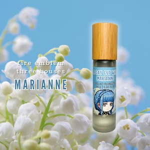 May include: A roll-on fragrance bottle with a wooden cap, featuring a label with a cartoon character and the text "A Day Out With Marianne." The background includes white flowers and the text "Fire Emblem Three Houses Marianne."