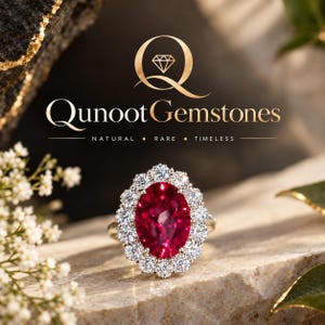 Könnte beinhalten: Ein Ring mit einem großen, oval geschliffenen, tiefroten Edelstein, der von einem Kranz aus kleinen, runden, weißen Diamanten umgeben ist. Der Text Qunoot Gemstones mit Diamant-Logo und NATURAL RARE TIMELESS steht in Gold darüber.