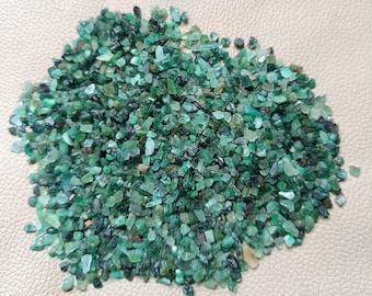 Könnte beinhalten: Eine Ansammlung kleiner, roher Smaragd-Edelsteinsplitter in verschiedenen Grüntönen, die von hellem Minzgrün bis zu tiefem Waldgrün reichen. Die Steine sind unregelmäßig in Form und Größe und weisen eine Mischung aus durchscheinenden und undurchsichtigen Texturen auf.