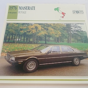 May include: A brown 1976 Maserati Royale car parked in a grassy area with trees in the background. The car has a white license plate and the text "SPORTS" is visible in the upper right corner of the image.
