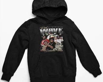 Könnte beinhalten: Schwarzer Kapuzenpullover mit einem grafischen Druck einer Gruppe von Personen mit Geld und dem Text "Rest Wave Believe Me".