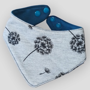 May include: A gray bandana with a blue trim and snap closures. The bandana features a repeating pattern of black dandelion silhouettes.